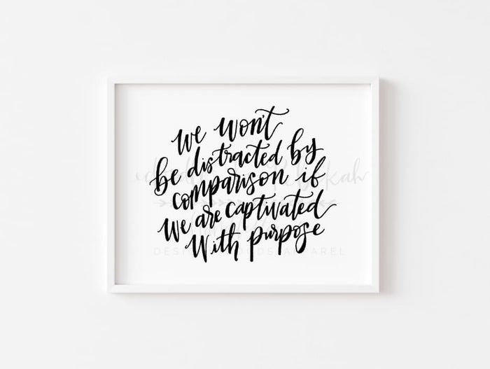 An 8x10 framable print featuring handwritten-style black text on a white background, with the text 'We will be distracted by comparison. But we are captivated by purpose.